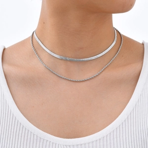 Détail d'un collier double couche en acier inoxydable avec chaîne plate et torsadée