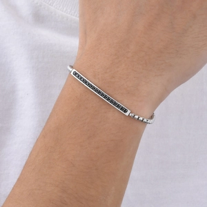Gros plan détaillé d'un bracelet chaîne box argenté avec pendentif rectangulaire en zircon noir