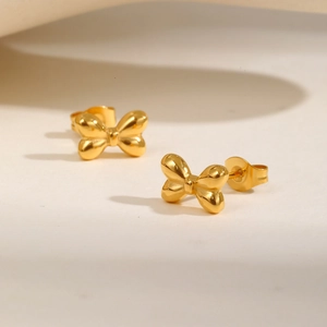 Gros plan de boucles d'oreilles nœuds dorés avec une finition métallique polie