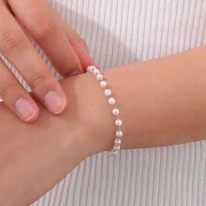 Minimalist gold stainless steel pearl beaded bracelet worn elegantly on a female wrist
