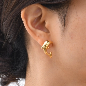 Polished gold dolphin stud earrings for women shown as a lifestyle shot on the ear