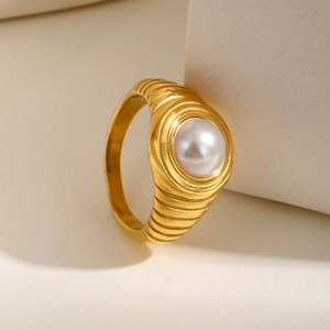 Détail d'une bague croissant plaquée or ornée d'une grande perle ronde et brillante