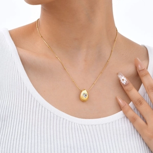 Goldene Edelstahlperlenkette mit herzförmigem Zirkonia-Wassertropfen-Anhänger an Model