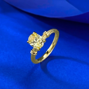 Macro view of gold plated S925 silver ring featuring an oval yellow gemstone on blue silk