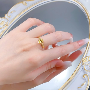 Detail of a vintage-style gold ring with an oval yellow gemstone and textured band