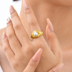 Bague en acier inoxydable doré avec perle blanche ronde sur le doigt d'un mannequin