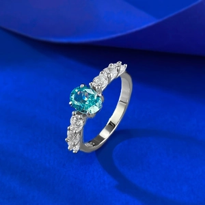 Gros plan d'une bague en argent S925 avec une pierre bleue ovale sur fond de soie sombre