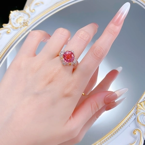 Macro detail of S925 silver ring with pink sapphire and baguette side stones on a finger
