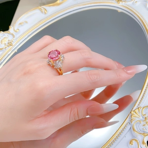 Macro shot of a luxury S925 silver ring with pink padparadscha stone on a mirror