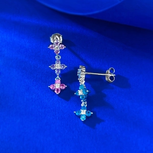 Close-up of S925 silver clover earrings with colorful gemstones on a blue background