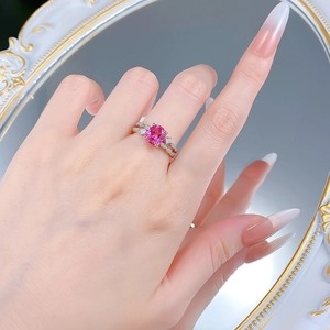 Macro shot of S925 silver ring featuring a pink cushion-cut gemstone on a finger