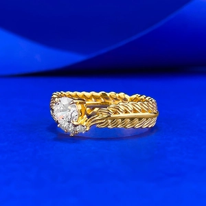 Macro detail of gold wheat ear ring with brilliant round center stone and feather textures