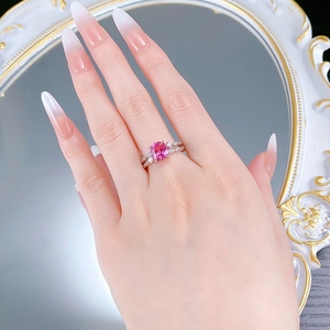 Macro view of a silver ring featuring a large pink rectangle gemstone and pave diamonds
