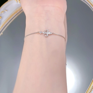 Detail of silver iris fleur-de-lis bracelet with star zircon on model's wrist