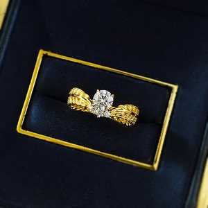Classic wheat ear patterned gold ring with a brilliant round center stone on velvet