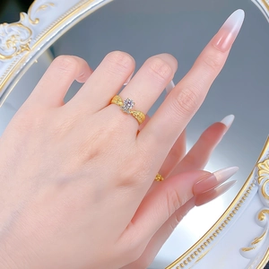 Detail of vintage gold wheat ear ring with round bright gemstone on finger