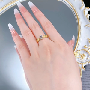 Close-up of golden wheat ear ring with round zircon worn on hand near a mirror