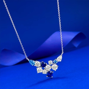 Detailed close-up of blue and white gemstone cluster pendant on silver chain