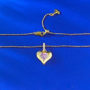 Collana cuore in argento S925 con zircone rosa su sfondo di seta blu profondo elegante