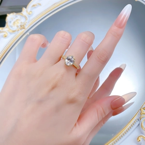 Macro shot of an oval-cut diamond ring with halo setting on a model finger