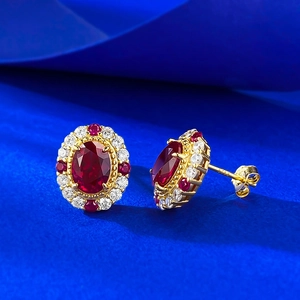 Gros plan détaillé d'une boucle d'oreille en argent S925 avec gemme rouge et halo de diamants