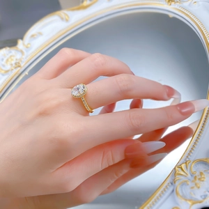 Elegant gold ring with oval cut white diamond and halo setting shown on a model