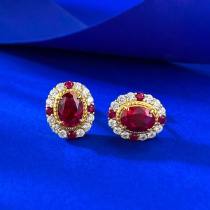 Boucles d'oreilles ovales en argent S925 rubis et diamants sur fond bleu nuit