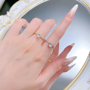 Detail of 1 carat oval solitaire rings in gold and silver finish worn by a model