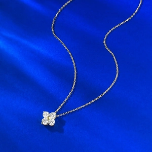 Exquisite S925 silver gold-plated clover pendant necklace on deep blue silk backdrop