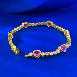 Detail of gold-plated S925 silver bracelet with pink heart stones and pavé diamonds