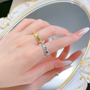 Close-up of gold and silver S925 rings with sparkling crushed ice pavé setting on hand