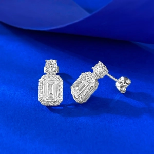 Vue détaillée des boucles d'oreilles en argent S925 taille émeraude sur fond bleu