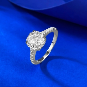 Close-up of a 2.5 carat octagonal cut silver ring with pavé diamonds on blue velvet