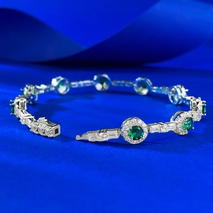Vue détaillée du bracelet en argent S925 avec émeraudes et zircons blancs sur fond bleu