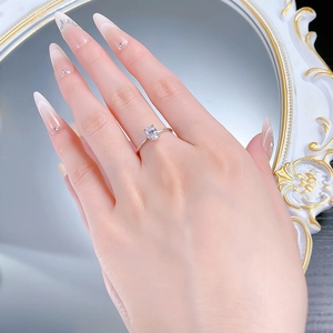 Detailed view of an S925 silver ring with a 1-carat emerald cut solitaire stone on a finger