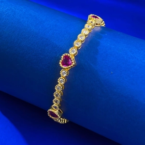 S925 silver gold-plated bracelet with red heart stones and pavé diamonds on blue pedestal