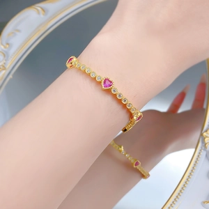 Detailed view of a gold S925 silver bracelet with pink heart stones and pavé diamonds