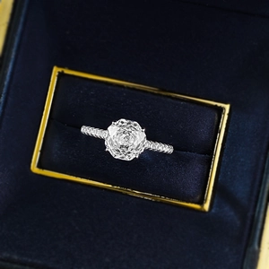 Macro view of rose-cut central gemstone with pave diamond band in blue velvet box