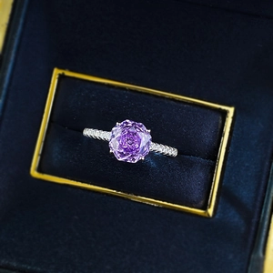 Macro detail of a 925 silver ring featuring a purple rose-cut stone in a blue velvet box