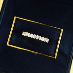 Macro view of gold S925 silver eternity ring with oval-cut diamonds in blue velvet box