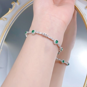 Gros plan d'un bracelet de tennis en argent S925 avec pierres vertes et cristaux brillants