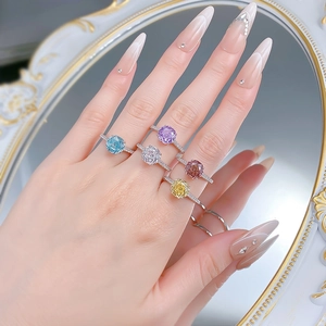 Close-up of five S925 silver rings with colorful octagonal cut gemstones on a hand