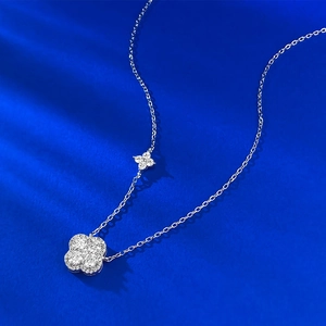 Detailed view of silver double clover necklace with diamond-set sparkling pendants
