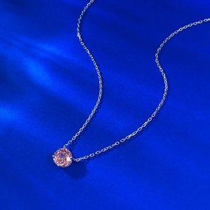 Macro shot of S925 silver necklace with 2.5ct pink round gemstone on blue background