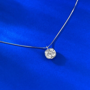 Detail view of the silver box chain necklace with a geometric square-shaped pendant