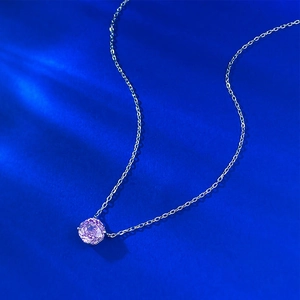 Macro detail of S925 silver necklace with round cut purple gemstone pendant on blue base