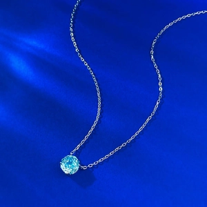 Close-up of S925 silver necklace with a 2.5 carat blue gemstone pendant on a blue background