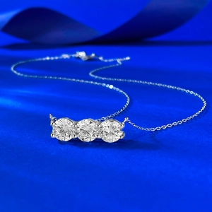 Collana in argento S925 con tre pietre rotonde su sfondo di velluto blu scuro