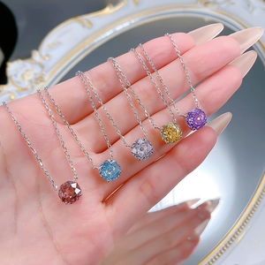 Detailed close-up of colorful 2.5 carat round cut gemstone pendants on silver chains