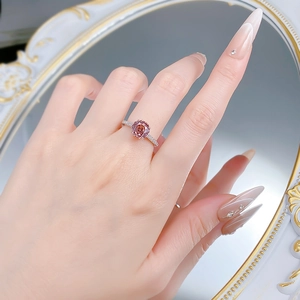 Detail of pink octagonal stone silver ring with side stones on a mirror background